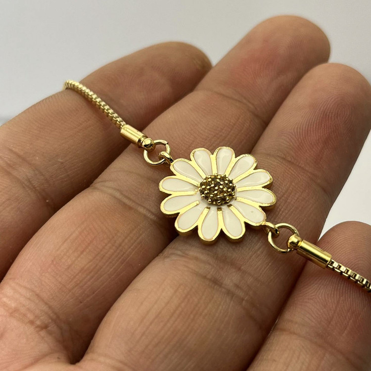 دستبند طلایی زنانه با مرکز نگیندار و گل مینای سفید