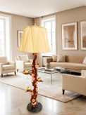آباژور ایستاده کنارسالنی دستساز با پایه طرح شاخه و پرنده، شید پارچهای کرم و نور گرم در دکوراسیون پذیرایی